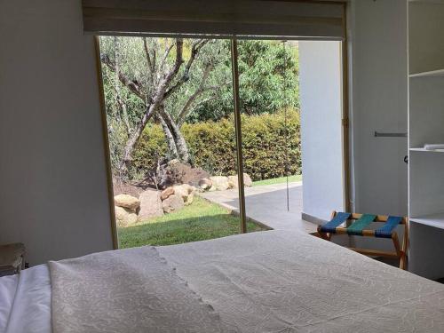 een slaapkamer met een bed en een groot glazen raam bij Casa de los Olivos! in Villa de Leyva