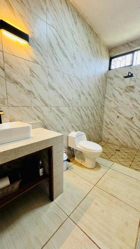 a bathroom with a white toilet and a sink at Estudio a 5 minutos de Sayulita -Parota 1 in San Ignacio