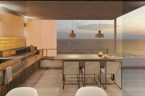 a kitchen with a dining table and a view of the ocean at La mejor Vista al Point de la Playa San Bartolo in San Bartolo