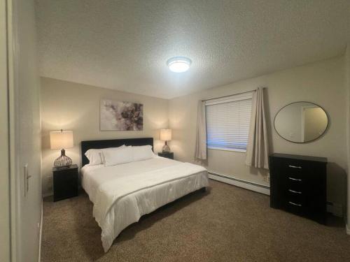 - une chambre avec un lit, un miroir et une fenêtre dans l'établissement Northern Knights, à Fairbanks