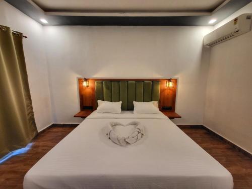 a bedroom with a bed with a heart on it at Rashiva Resort in Arambol