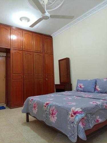sypialnia z łóżkiem i drewnianymi szafkami w obiekcie D'HYA HOMESTAY w mieście Alor Setar