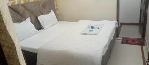 a bed with white sheets and a bottle on it at Hotel king palace in Chandīgarh