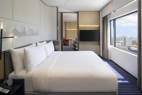 a bedroom with a large white bed and a large window at Crowne Plaza Bangkok Lumpini Park, an IHG Hotel in Bangkok