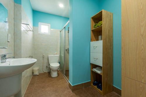 a bathroom with a sink and a toilet and blue walls at Amaia Homestay - a beach home away from home in Phú Quốc