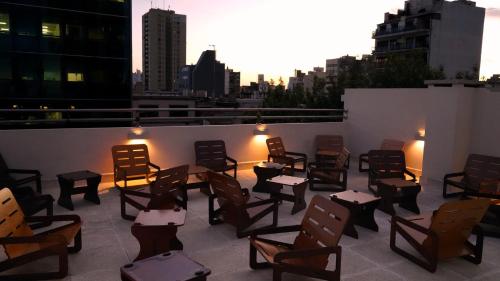 a patio with chairs and tables on a rooftop at Hotel Athos in Buenos Aires