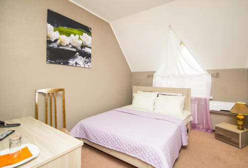 1 dormitorio con 1 cama con sábanas blancas y ventana en Guest House Gamma, en Khanty-Mansiysk