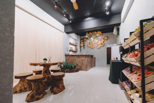 a bakery with wooden stools and a table with food at 宥心文旅You Sin B&B in Donggang