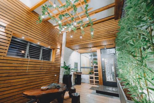 a lobby with wooden walls and a table and plants at 宥心文旅You Sin B&B in Donggang
