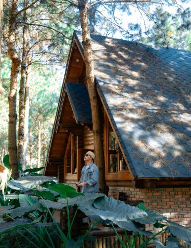 a woman standing in front of a tiny house at The Nordic Village - Evergreen Retreat in Mộc Châu