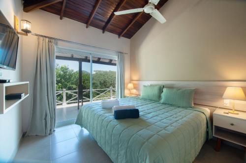 a bedroom with a bed with a large window at Vista Alegre Natural Resort - Villas & Cabañas in Independencia
