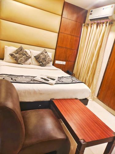 a small bedroom with a bed and a chair at Santhi Bhavan, Chennai Central in Chennai