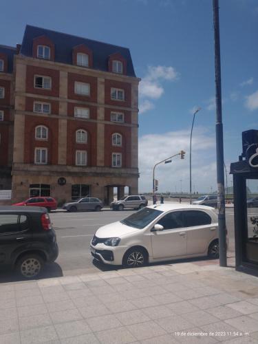馬德普拉塔的住宿－Cielo azúl，两辆汽车停在大楼旁边的停车场