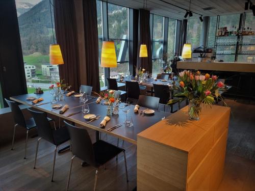 a dining room with a long table with flowers on it at 54 Hochgenuss in Schattdorf