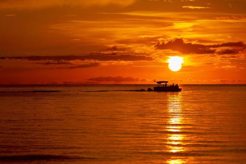 - un bateau dans l'océan au coucher du soleil dans l'établissement Sorrento Cabana, à Naples