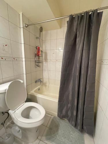 a bathroom with a toilet and a shower curtain at [NEW] Tumon 온비치하우스 - 갤러리아 뒷편 / 투몬비치 도보 7분거리 in Tumon