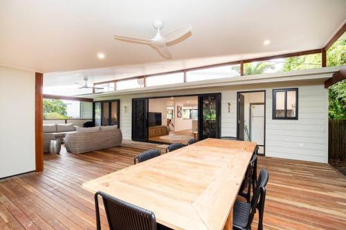 a dining room with a wooden table and a ceiling fan at Island Hideaway + 1 min to Cylinder Beach + Sleeps 10 in Point Lookout