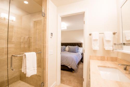 1 cama y baño con ducha y lavabo. en Dollar Meadows Condo 1376 - Newly Renovated & Access to Sun Valley Resort Pool, en Sun Valley