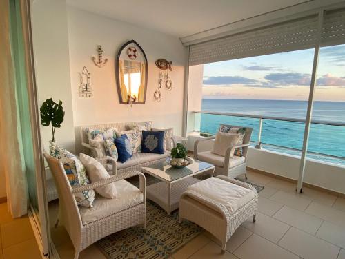 a living room with a view of the ocean at Majestuoso Apto. en el Complejo Marbella, Juan Dolio in Juan Pedro