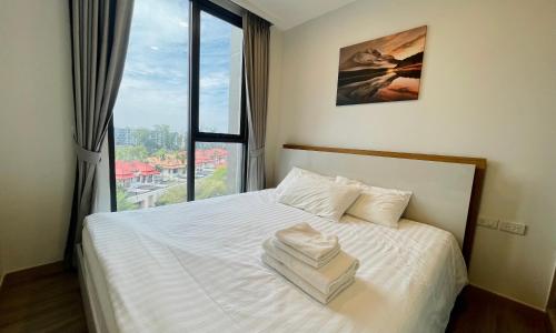 Schlafzimmer mit einem weißen Bett und einem großen Fenster in der Unterkunft Laguna Skypark in Phuket