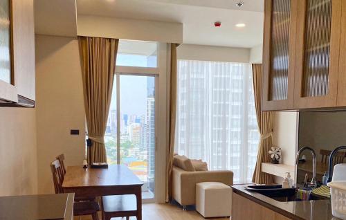 een keuken en een woonkamer met een groot raam bij 2 Bedroom Luxury Apartment 3 min walk from BTS Ekkamai in Bangkok