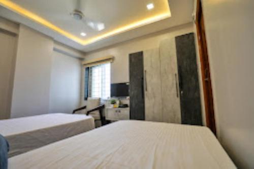 una camera d'albergo con due letti e una finestra di Hotel Jataka Inn , Bodh Gaya a Bodh Gaya