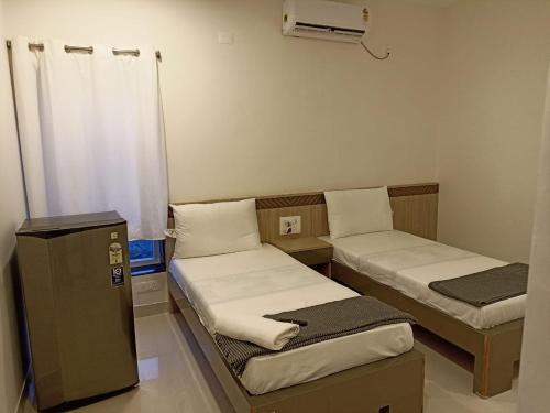 Habitación pequeña con 2 camas y calentador en Hotel Jataka Inn , Bodh Gaya, en Bodh Gaya