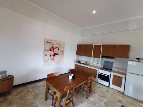 a kitchen with a wooden table and a kitchen with white appliances at Bukit Jaya Residence & Apartment Semarang in Semarang