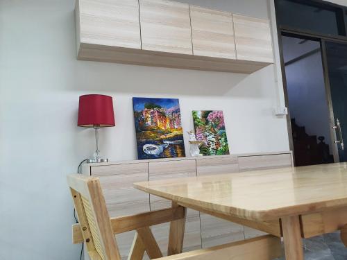 a dining room table with two paintings on the wall at 3 BR Cozy Home Skytrain View BKK in Bangkok