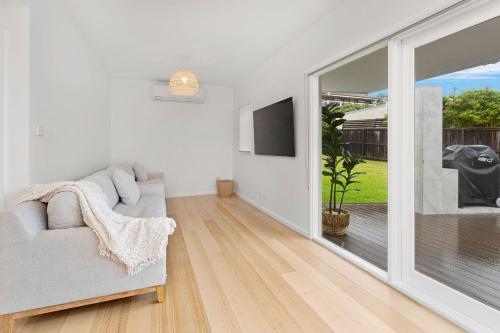 a living room with a couch and a sliding glass door at Prime Position in Gerroa