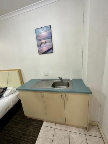 a bathroom with a sink in a room with a bed at Jacksons Motor Inn in Adelaide