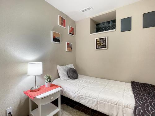 a bedroom with a bed and a table with a lamp at Chic 2br - 2 Min From Icubs in Des Moines