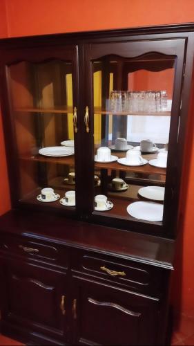 a cabinet with plates and dishes in it at Departamento en Cuenca in Cuenca