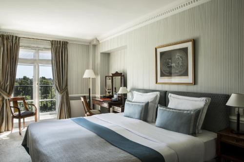 パリにあるオテル ブライトン エスプリ ドゥ フランスの大きなベッドとデスクが備わるホテルルームです。