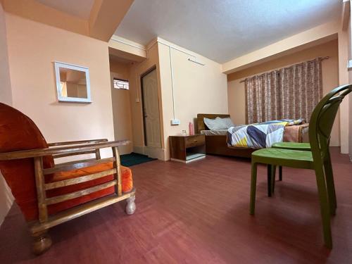 Deepjen Homestay في دارجيلنغ: غرفة بسرير واريكة وكرسي