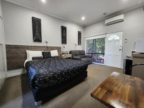 ein Schlafzimmer mit einem Bett und ein Wohnzimmer in der Unterkunft Motel24Seven and Apartments in Sale