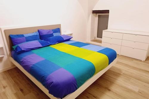 een slaapkamer met een kleurrijk bed en een dressoir bij Archidante in Bari