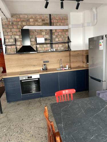 a kitchen with a sink and a refrigerator and a table at Alma Villa Guest House - Bosteri in Bosteri