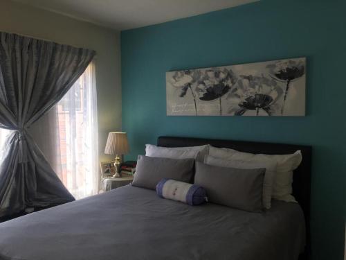 a bedroom with a large bed with a window at Karaboapartlodge in Jane Furse