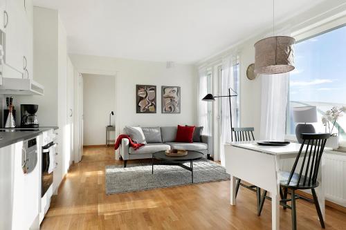 Guestly Homes - 1BR Corporate Comfort في بودن: غرفة معيشة مع أريكة وطاولة