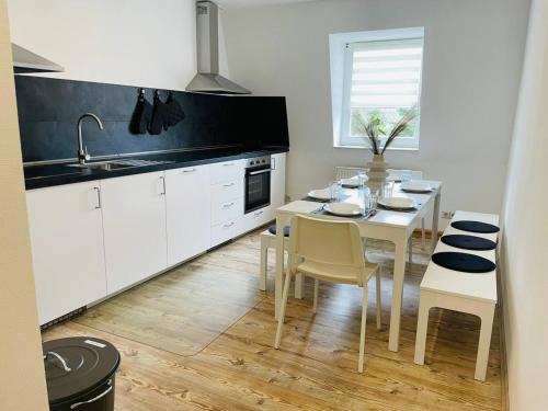 una cucina con tavolo, sedie e lavandino di cozy Apartment/WLAN in Neustadt i. Sachsen a Neustadt in Sachsen