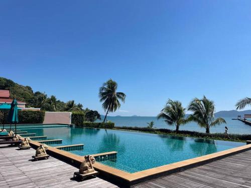 a swimming pool with the ocean in the background at Panoramic sea view, 1 bed flat in Ban Bang Bao