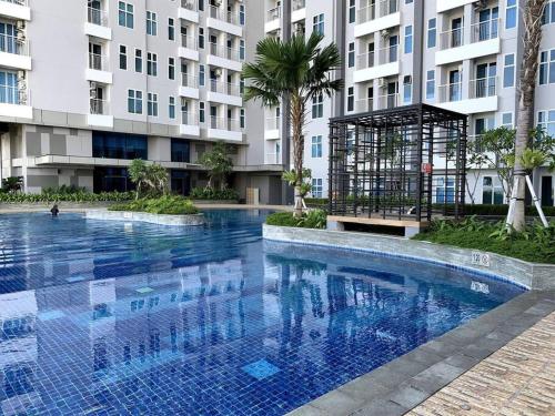 a large swimming pool in front of a building at Cozy Apartment on Top of Pakuwon City Mall in Surabaya