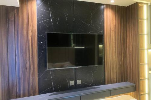a bathroom with a black wall with a mirror at Cozy Apartment on Top of Pakuwon City Mall in Surabaya
