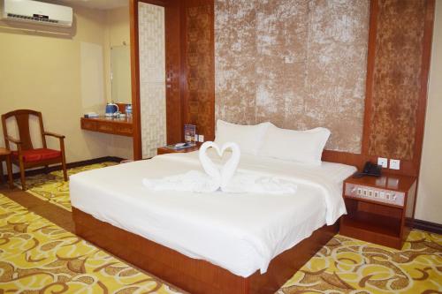 a bedroom with a bed with a swan decoration on it at Dansavanh Vientiane Hotel in Vientiane