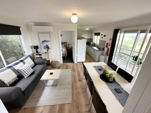 a living room with a couch and a table at Tidal Dreaming Seaview Cottages in Yanakie