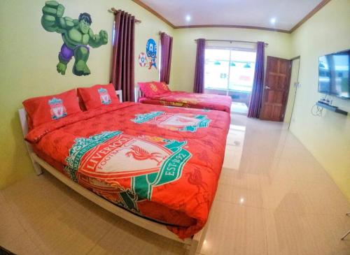 a bedroom with a large bed with a superhero bedspread at Green house Pool Villa in Cha Am