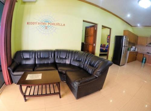 a living room with a leather couch and a table at Green house Pool Villa in Cha Am