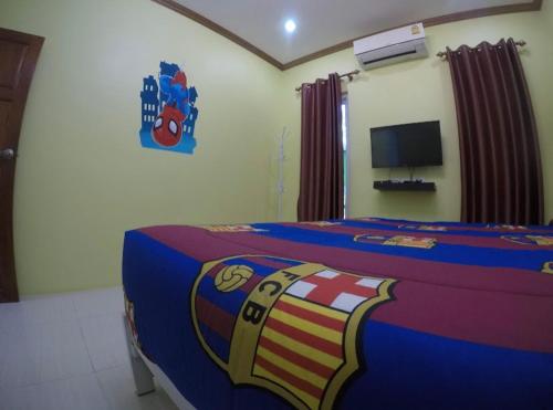 a bedroom with a bed with a blue and red blanket at Green house Pool Villa in Cha Am