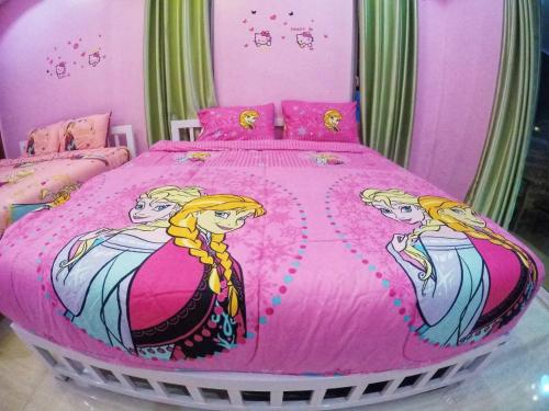 a bedroom with a pink bed with tworielles on it at Green house Pool Villa in Cha Am